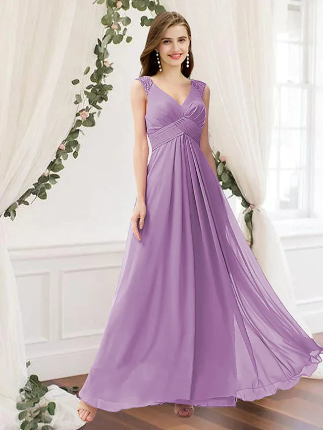 Woman wearing an elegant dark blue A-line V-neck chiffon bridesmaid dress with pleats and ruching.