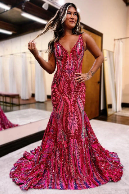 Model wearing a dark red sequin mermaid prom dress with a V-neckline, posing elegantly.