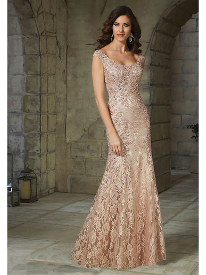 Woman wearing an elegant floral lace mermaid trumpet gown with a scoop neck.