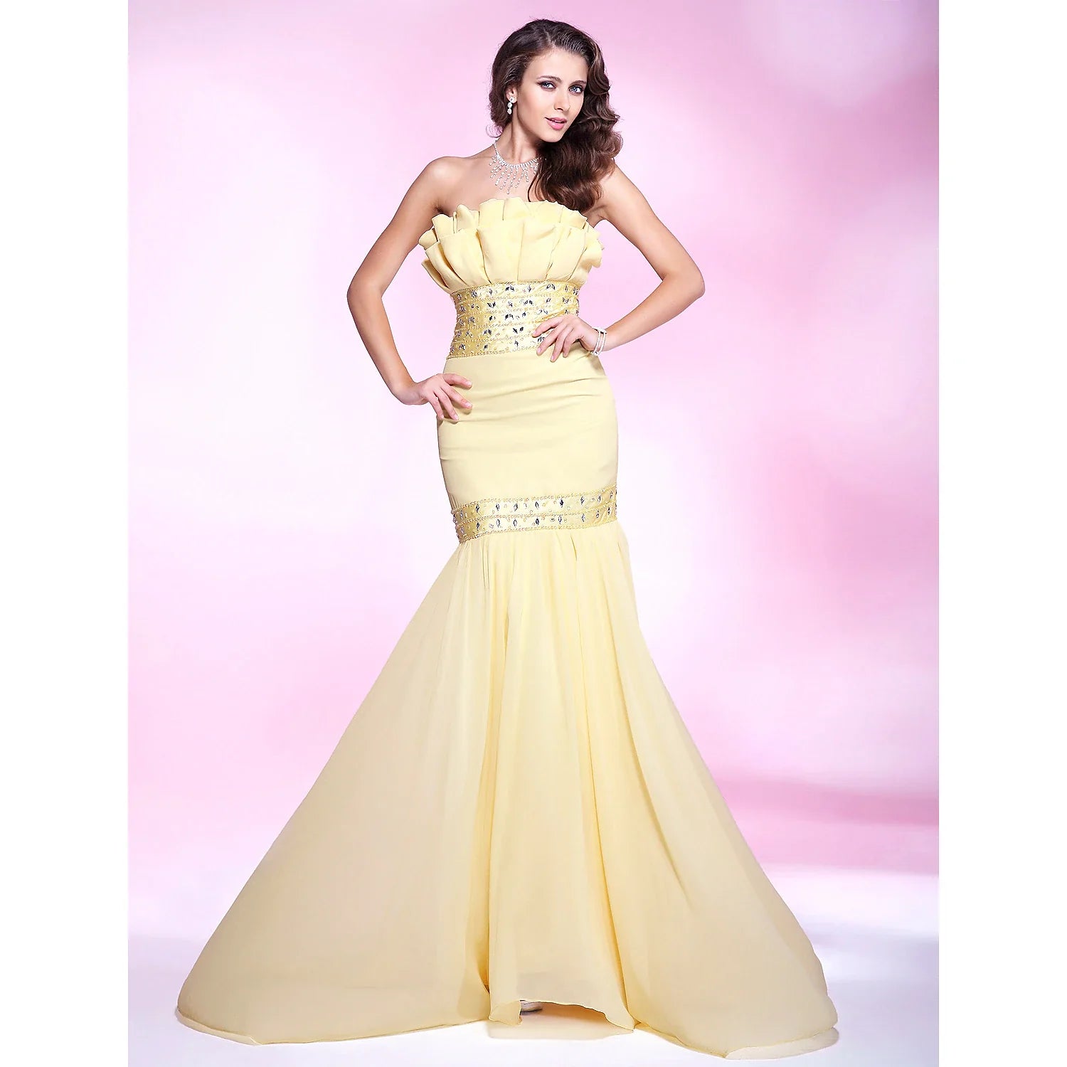 Woman in an elegant light blue mermaid trumpet formal gown with beading and ruffles.