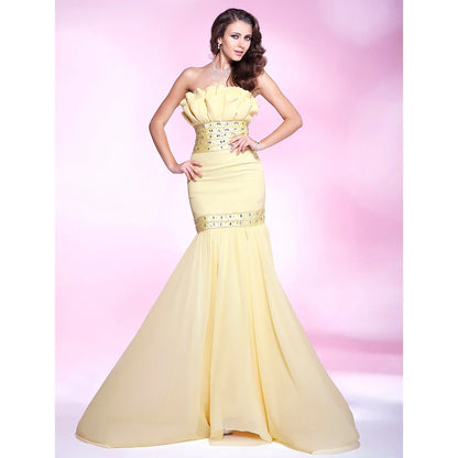 Woman in an elegant light blue mermaid trumpet formal gown with beading and ruffles.