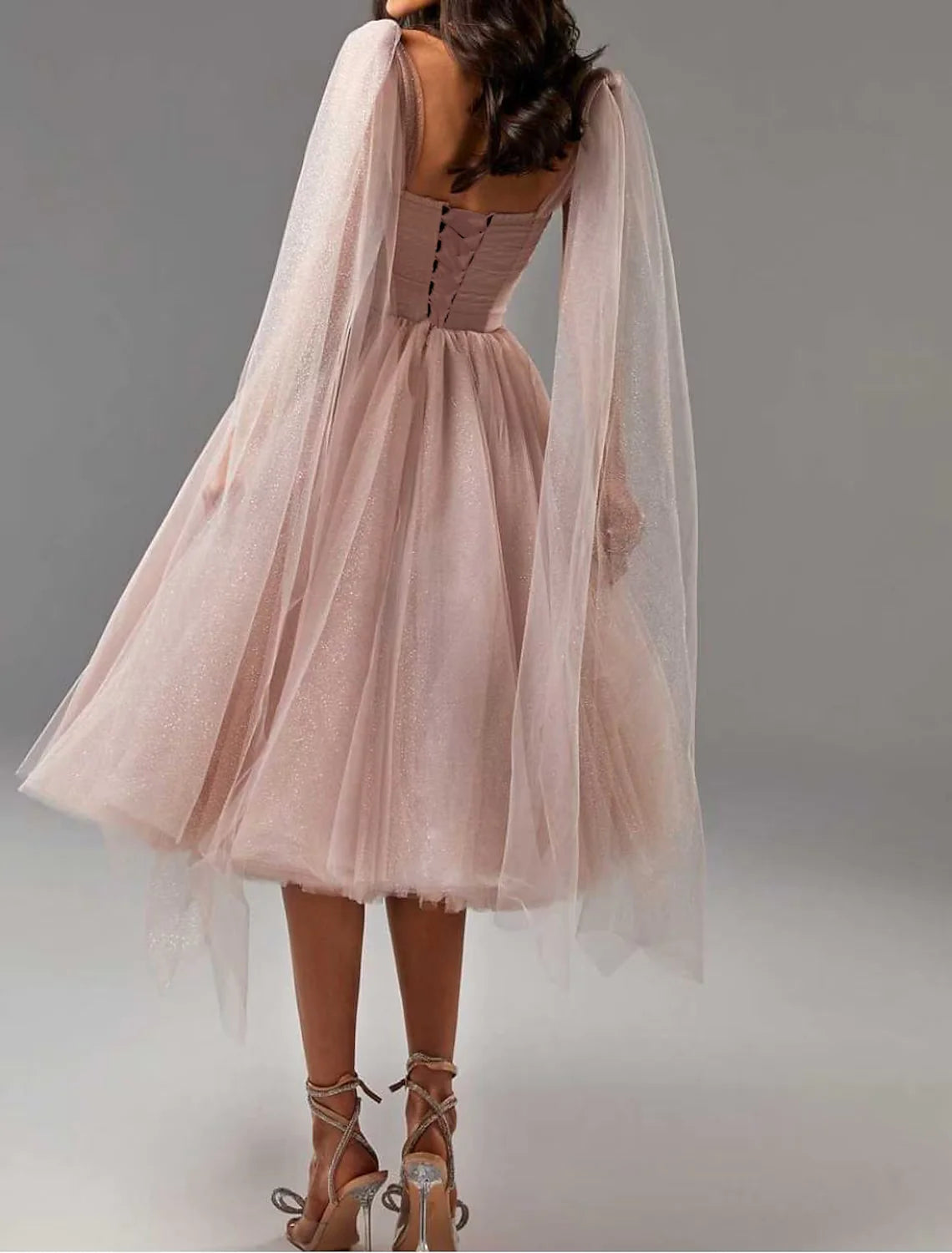 Side view of the glitter tulle ball gown, highlighting the tea-length skirt and sleeveless design.