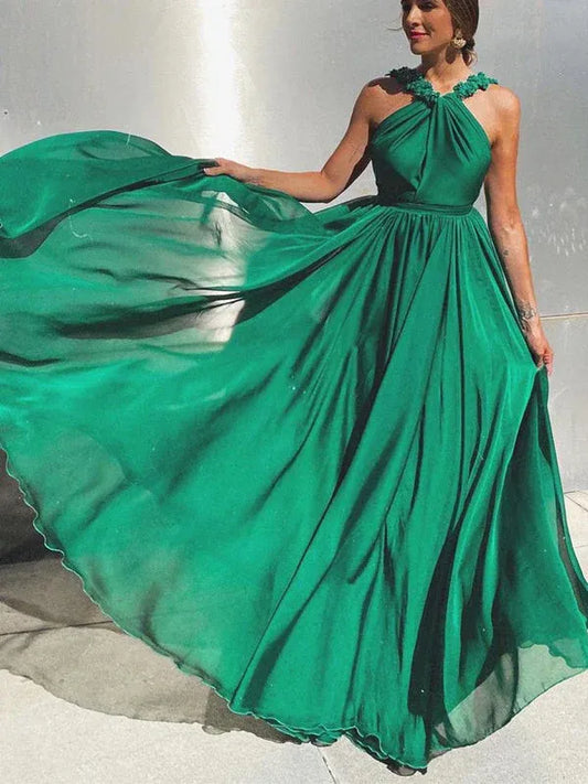 Green A-line prom dress with halter neck, floral applique, and open back design.