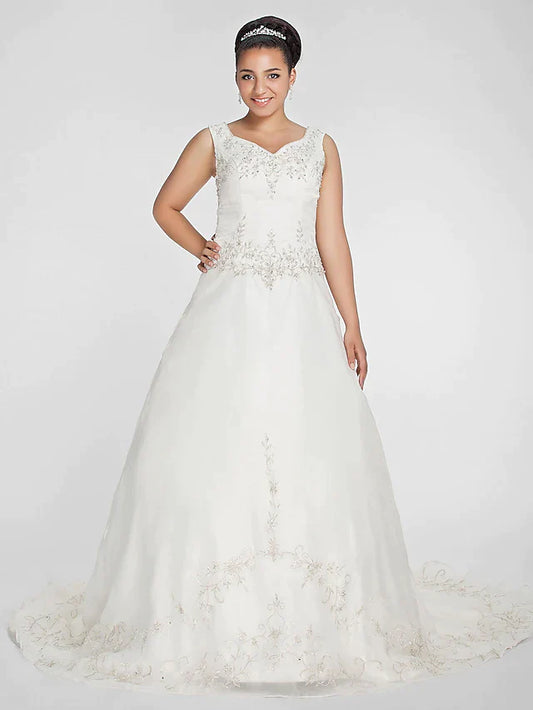 Front view of an elegant ivory plus size ball gown wedding dress with V-neck and beaded lace bodice.