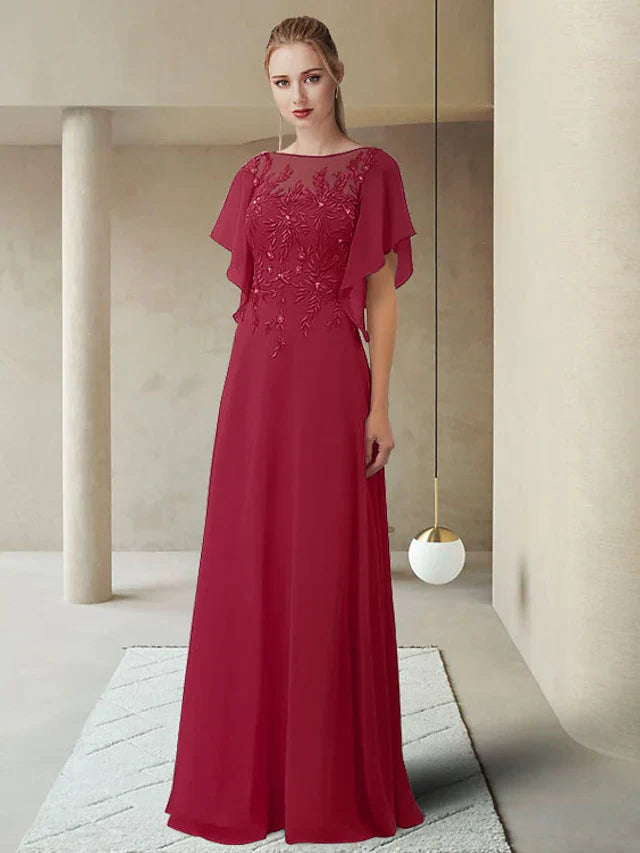 Woman wearing an elegant jewel neck, half-sleeve, floor-length Mother of the Bride dress with lace appliques.