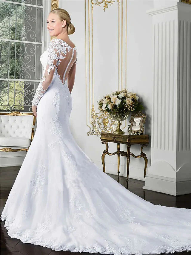 Back view of a white lace wedding gown, highlighting the long sleeves and flowing court train.