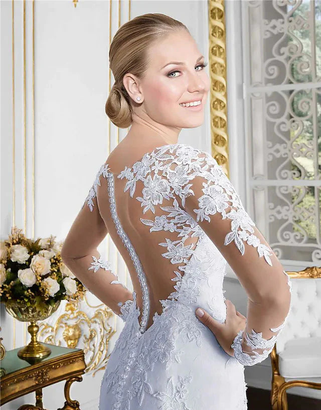 Close-up of the bodice and long lace sleeves of a white bridal gown with a jewel neckline.
