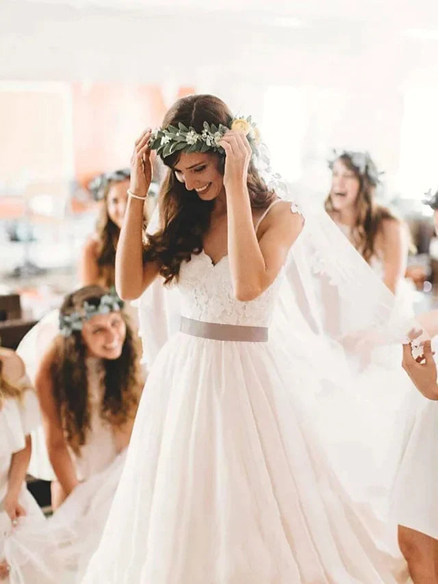 Close-up of the lace tulle bodice and spaghetti straps of the wedding dress.