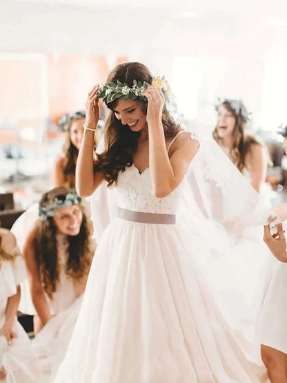 Close-up of the lace tulle bodice and spaghetti straps of the wedding dress.