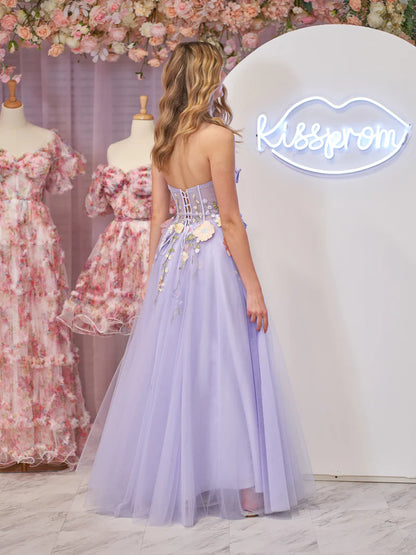 Model posing in a lavender A-line strapless tulle dress with floral details.