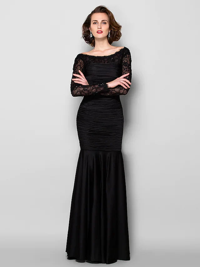 Woman wearing an elegant long sleeve Mother of the Bride dress with jewel neck and lace details.