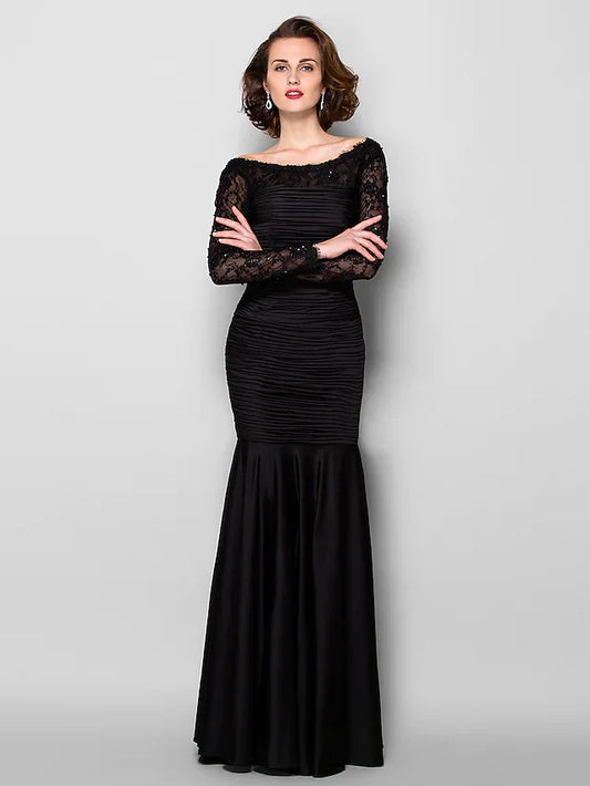 Woman wearing an elegant long sleeve Mother of the Bride dress with jewel neck and lace details.
