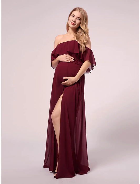 Woman wearing a black ruched long maxi party dress with U-neck and short sleeves.