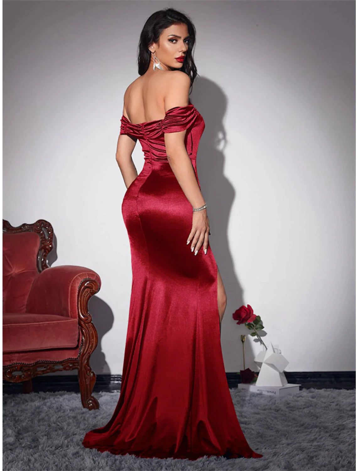 Side view of woman in navy blue mermaid gown, showcasing sweep train.