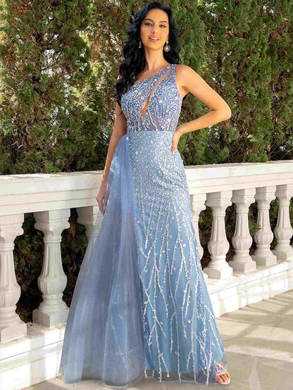 Model wearing a shimmering one-shoulder mermaid trumpet evening gown with sequin tulle and a cut-out detail.