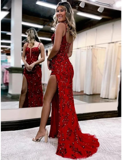 Side view of a woman wearing a white mermaid trumpet evening gown with appliques.