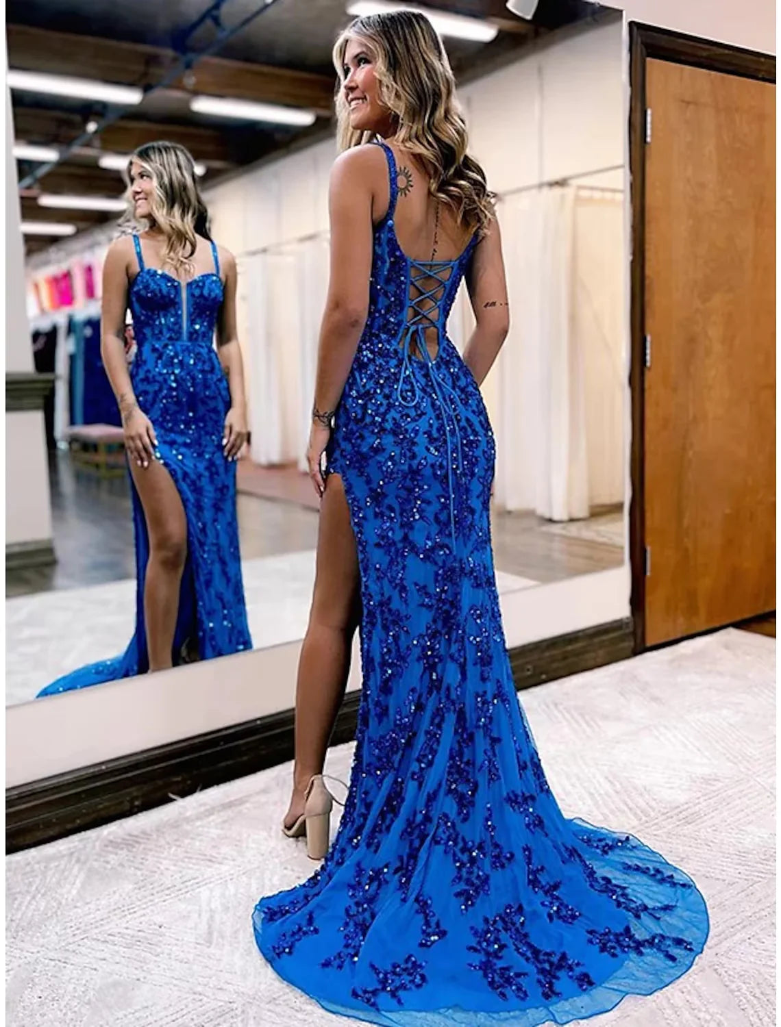 Back view of a woman in a white mermaid trumpet evening gown, highlighting the elegant silhouette.