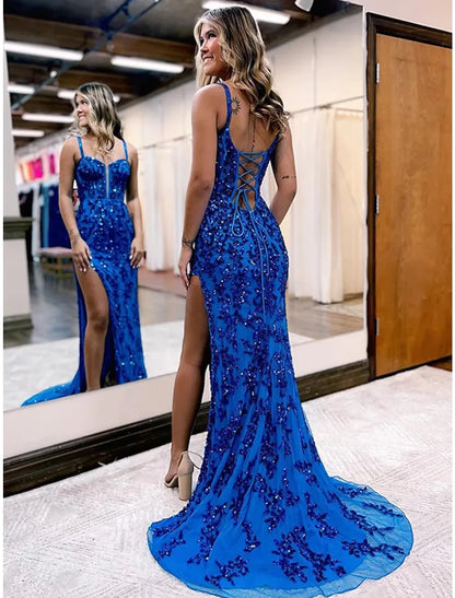 Back view of a woman in a white mermaid trumpet evening gown, highlighting the elegant silhouette.