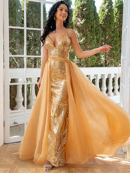 Elegant woman wearing a sequined mermaid trumpet evening gown with detachable tulle.