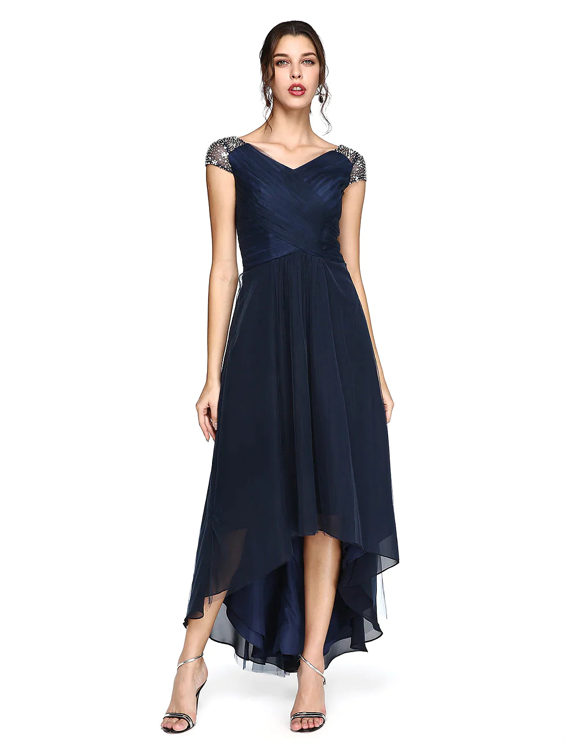 Model wearing an elegant light-colored sheath column wedding guest dress with V-neck and asymmetrical short sleeves.