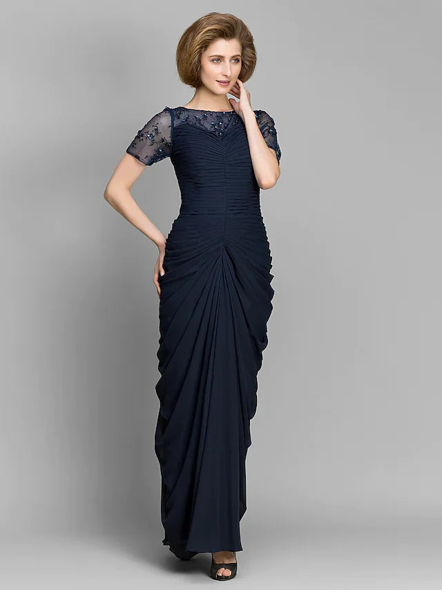 Woman wearing an elegant navy bateau neck short sleeve ruched chiffon floor-length dress.