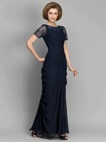 Close-up of the bateau neckline and ruched bodice with beading on the navy dress.