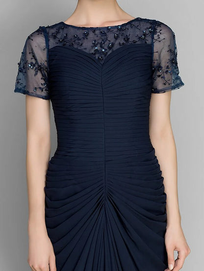 Woman in the navy chiffon dress, showcasing the flowing skirt and floor-length design.