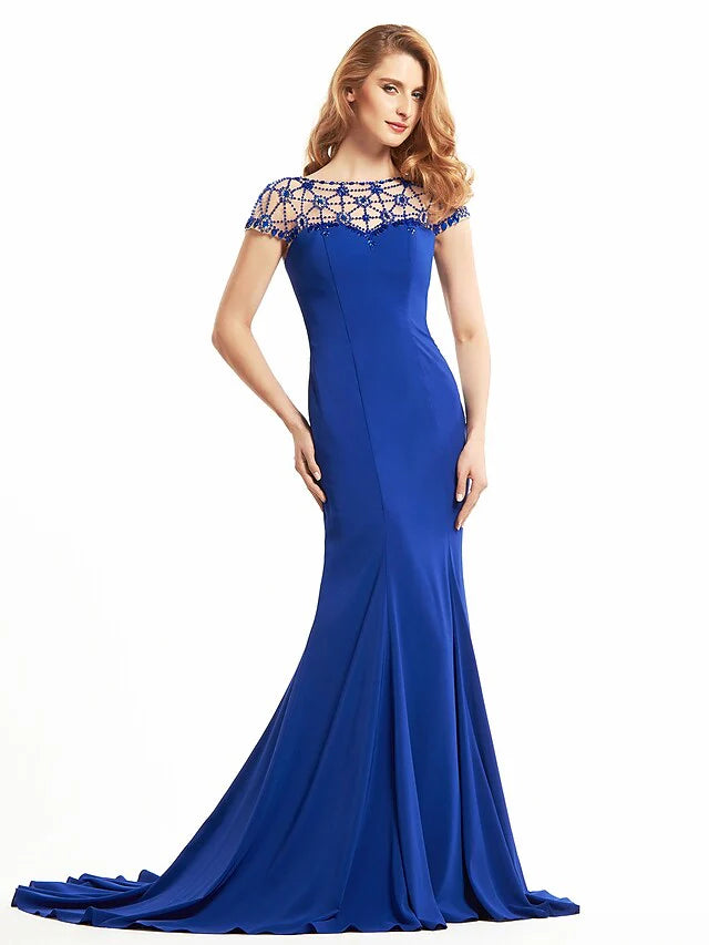 Woman wearing an elegant navy Mother of the Bride dress with a bateau neck and short sleeves.