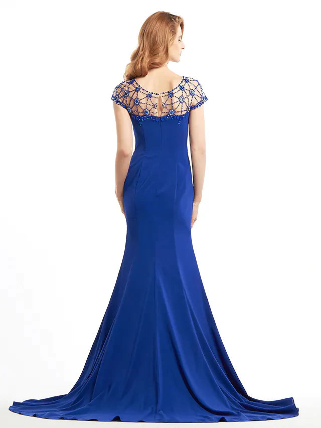 Side view of a woman in a navy beaded jersey Mother of the Bride dress.