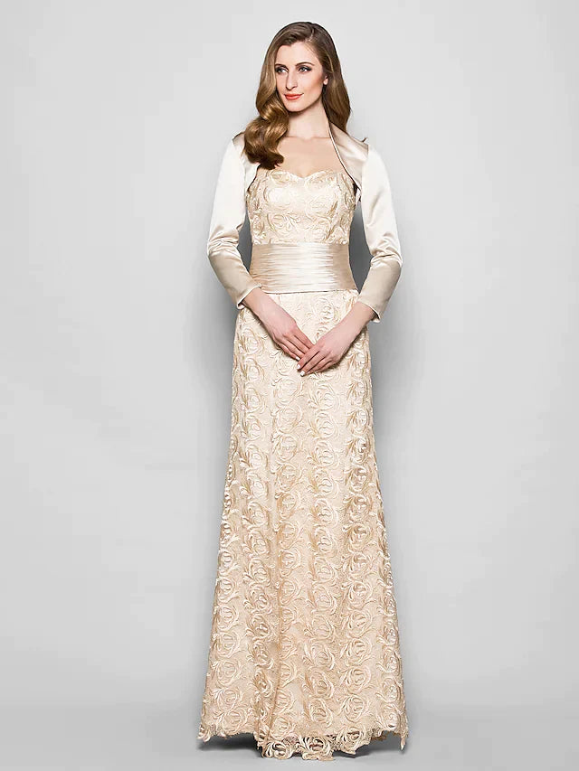 Woman wearing an elegant navy blue lace and satin mother of the bride dress with a sweetheart neckline and 3/4 sleeves.