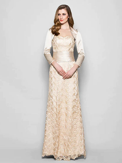Woman wearing an elegant navy blue lace and satin mother of the bride dress with a sweetheart neckline and 3/4 sleeves.