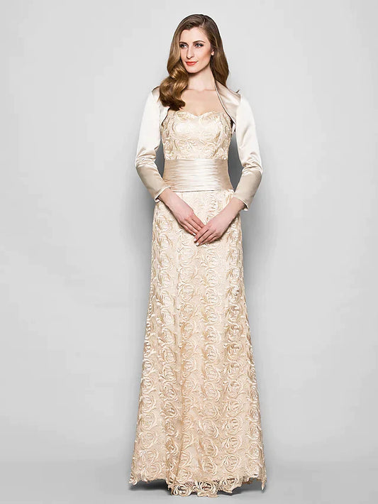 Woman wearing an elegant navy blue lace and satin mother of the bride dress with a sweetheart neckline and 3/4 sleeves.