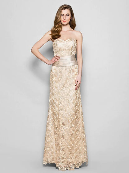 Another view of the woman in the navy blue lace satin dress, with the matching wrap draped over her arms.