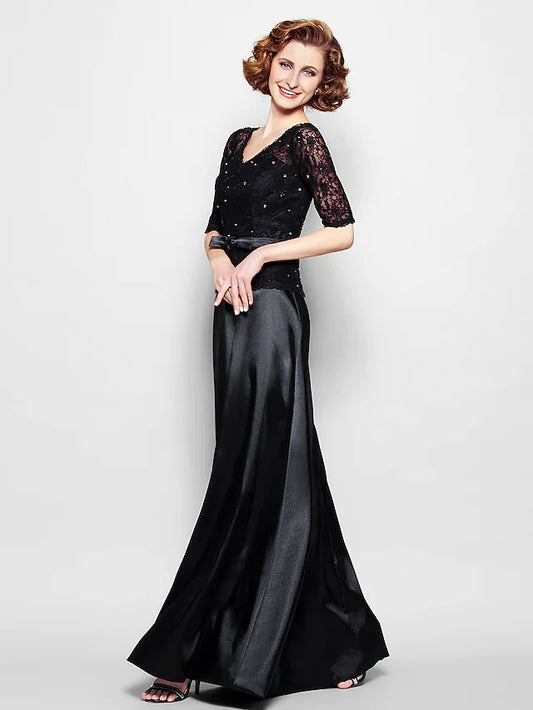 Woman wearing an elegant navy blue V-neck Mother of the Bride gown with lace and half sleeves.