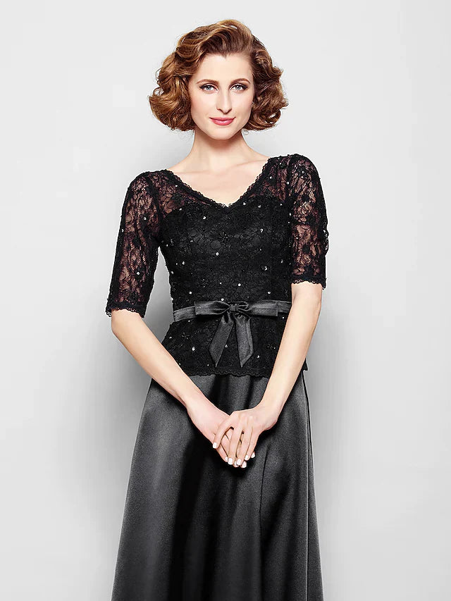 Close-up of the V-neckline and intricate lace details on the elegant navy blue gown.