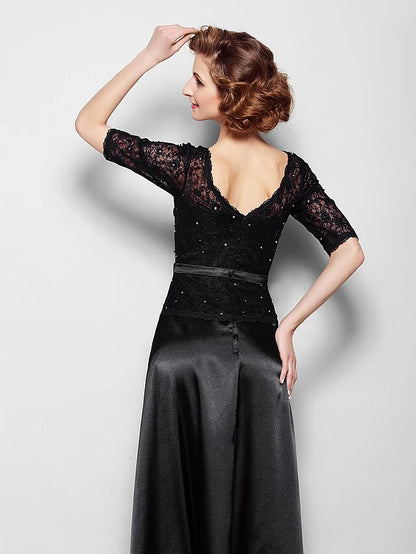 Woman posing gracefully in the navy blue half-sleeve Mother of the Bride dress.
