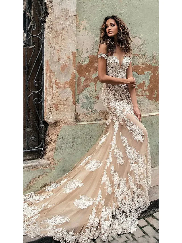 Bride wearing an elegant off-shoulder lace A-line wedding dress with a court train.