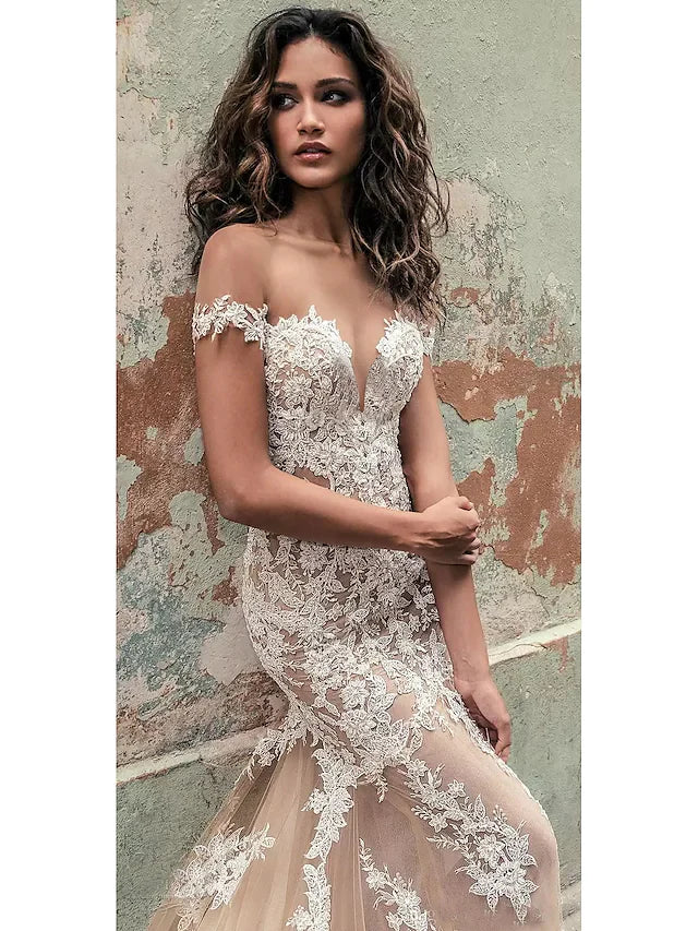 Back view of an off-shoulder lace wedding dress, showcasing the intricate court train.