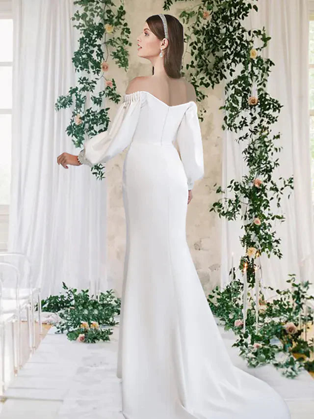 Back view of an off-shoulder half-sleeve wedding dress with a split front, on a model.