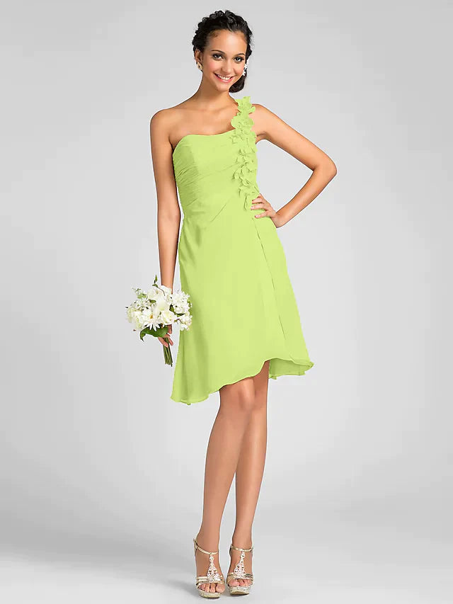 Rear view of a model in a one-shoulder knee-length chiffon dress, highlighting the back and side draping.