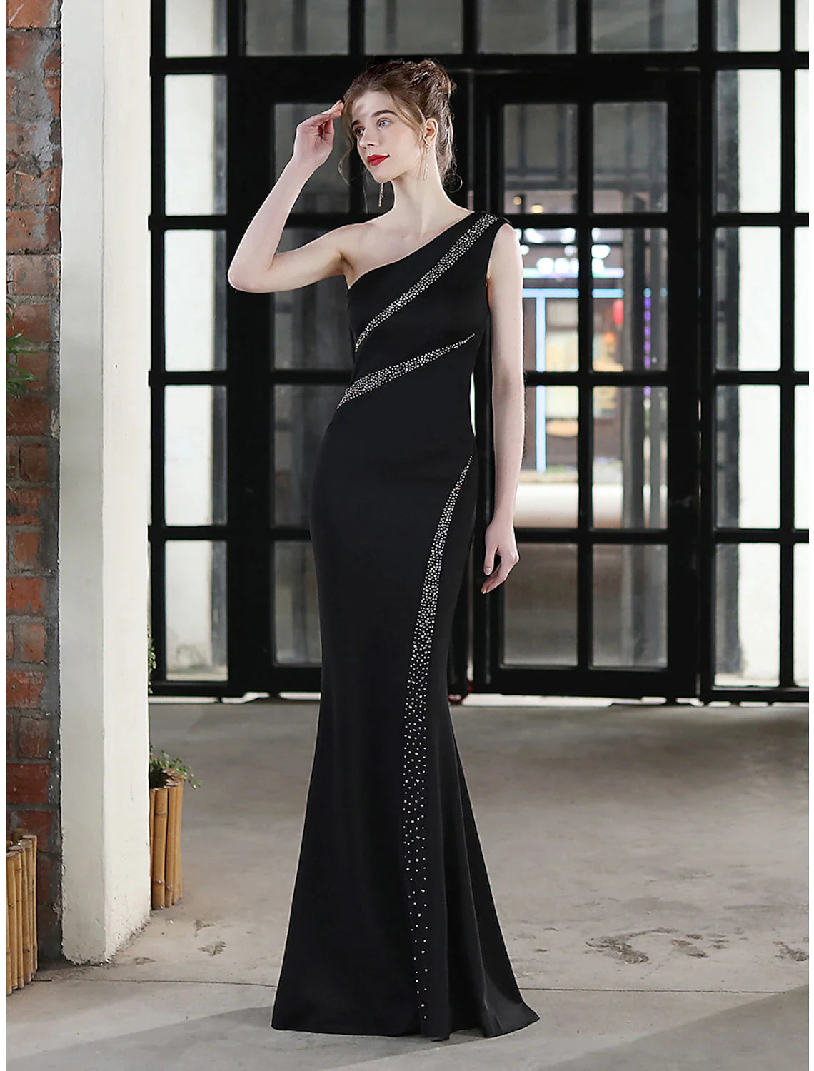 Side profile of a woman in an elegant mermaid evening dress.