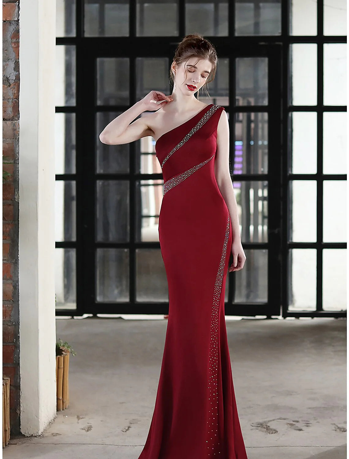 Woman posing gracefully in a stretch satin mermaid dress.
