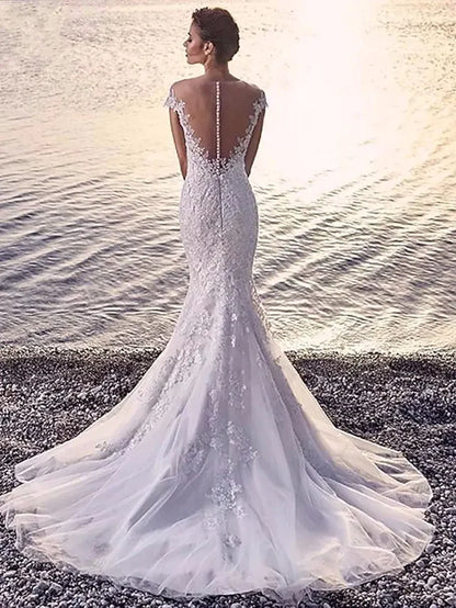 Back view of a model wearing the white organza wedding dress, showcasing the court train and delicate appliques.