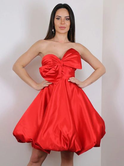 Side profile of a woman wearing a pink A-line satin mini dress, highlighting its flattering silhouette.
