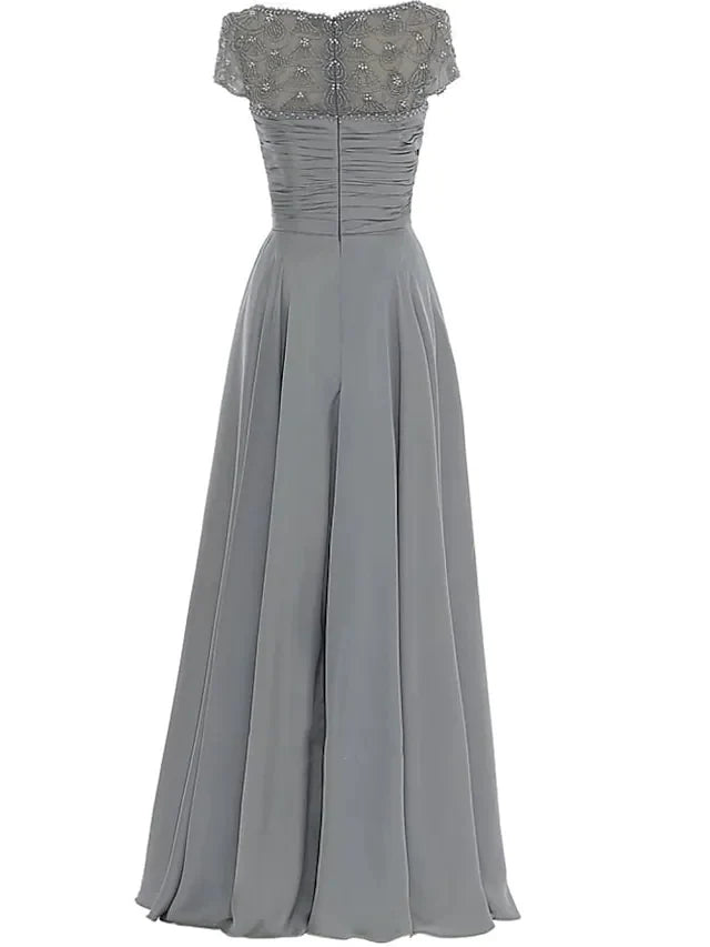 Close-up of the elegant chiffon Mother of the Bride dress, highlighting the jewel neck, beading, and pleats.