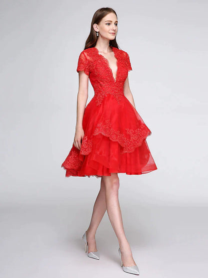 Model wearing an elegant knee-length ball gown with a plunging neckline and short sleeves, adorned with lace appliques.