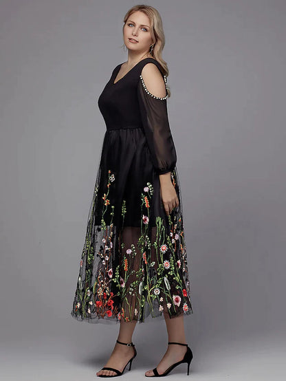Close-up of the dark A-line V-neck dress, highlighting the intricate beading appliques on the bodice and sleeves.