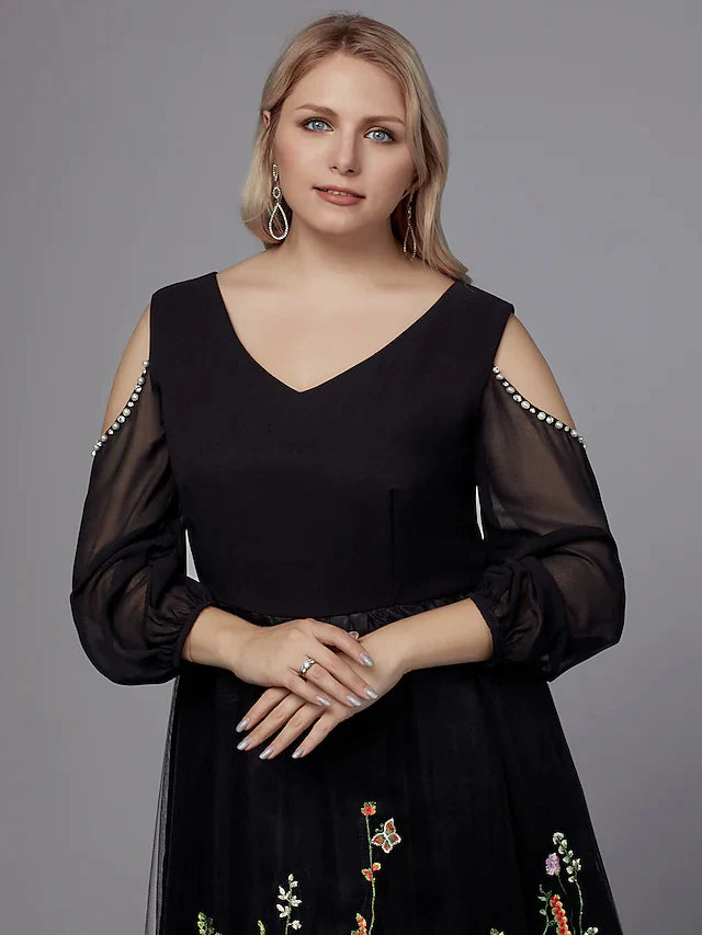 Plus size model gracefully posing in the dark A-line V-neck tea-length party dress.