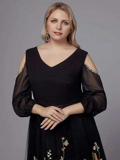 Plus size model gracefully posing in the dark A-line V-neck tea-length party dress.