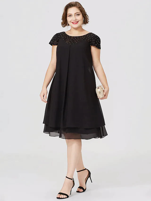 Plus size woman wearing a black chiffon lace Mother of the Bride dress, front view.